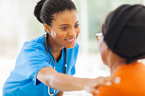 Smiling female nurse with her hand on a patient's shoulder