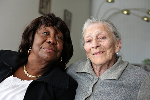Close up of two elderly women both smiling at the camera